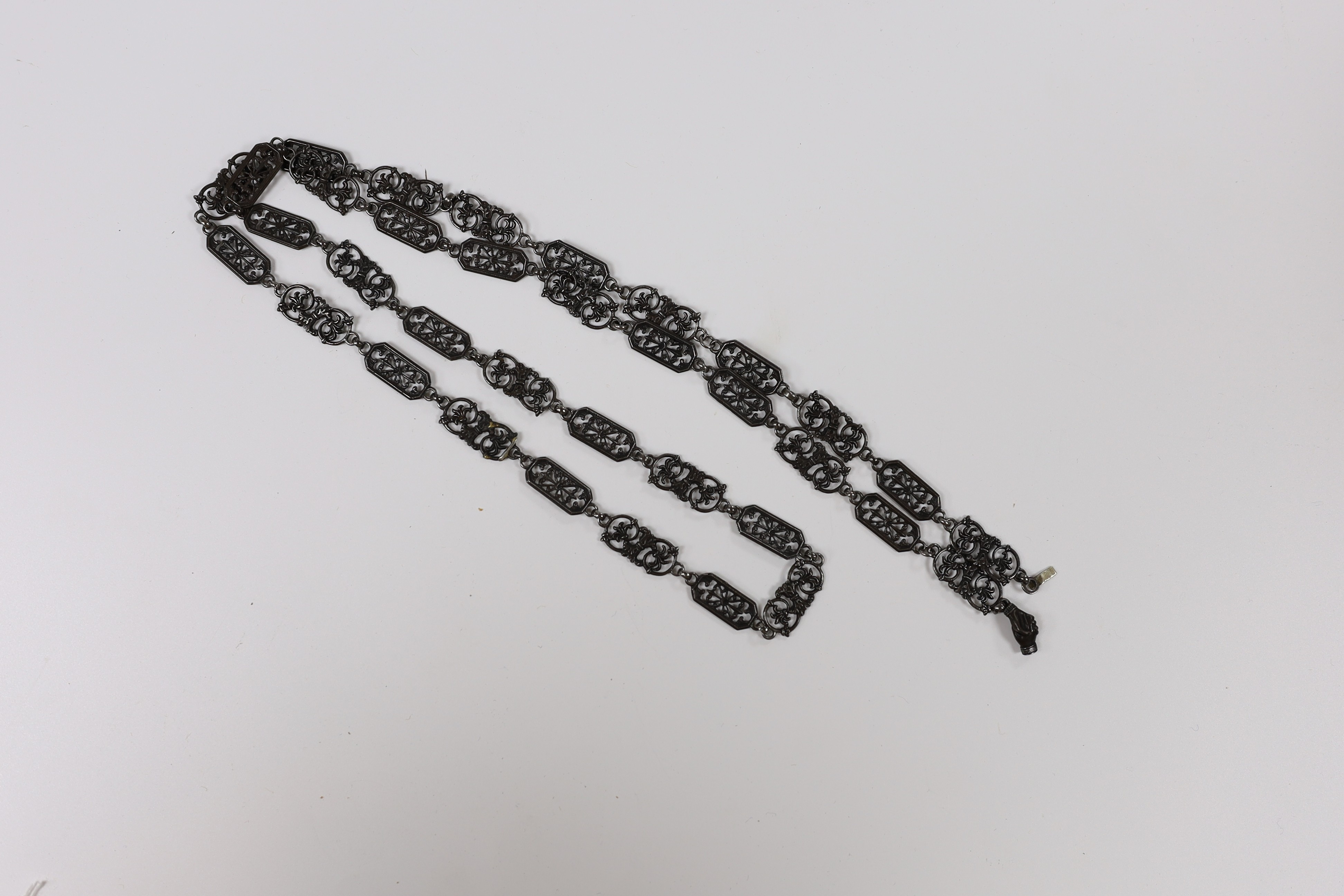 A 19th century Berlin iron work long necklace, with pierced octagonal and scrolling links, the clasp modelled as clasped hands, 114cm, (two small repairs to one link).